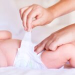 Cute baby boy relaxing while receiving a diaper change